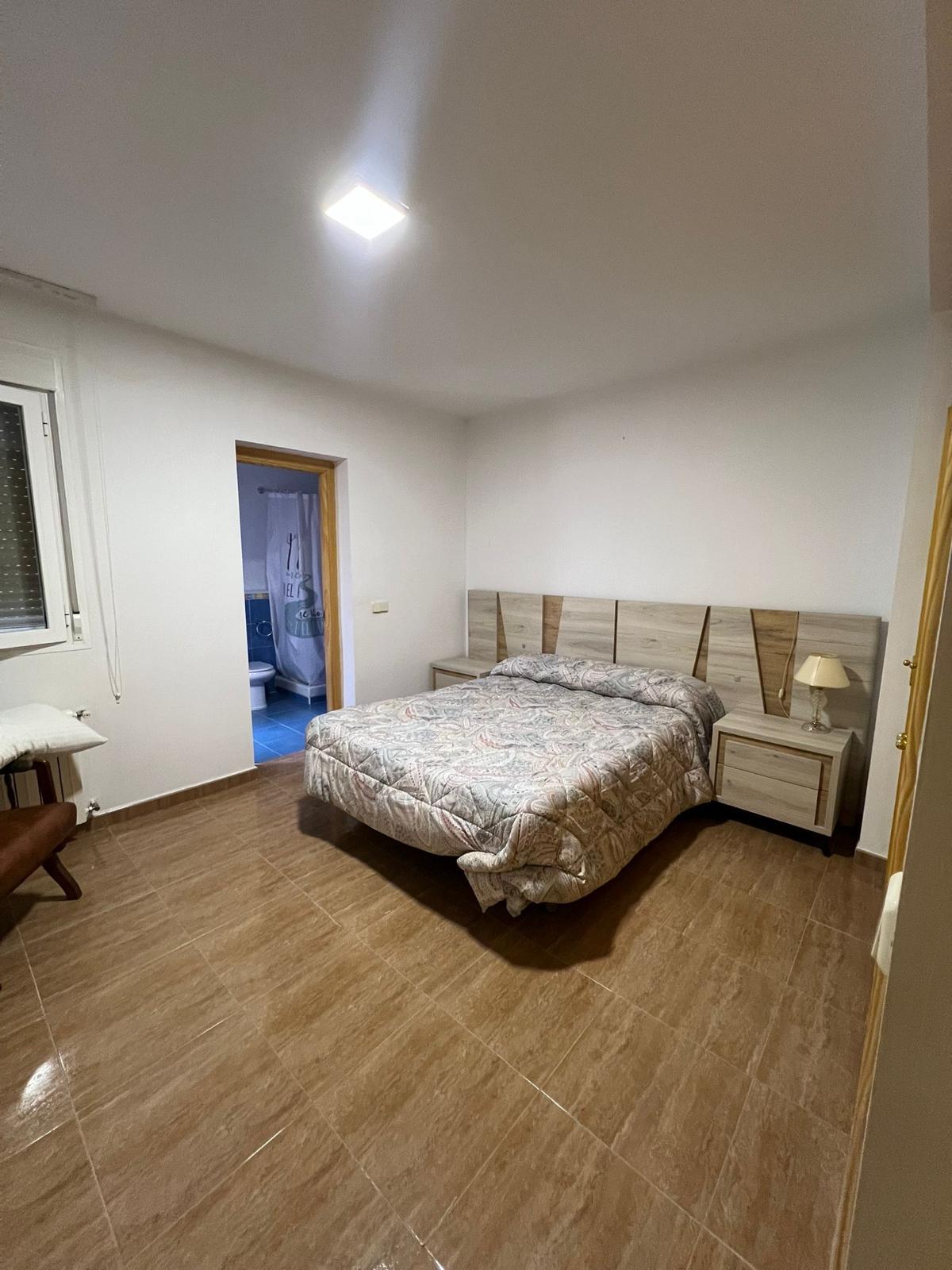 Habitación doble con cabecero de madera y baño propio