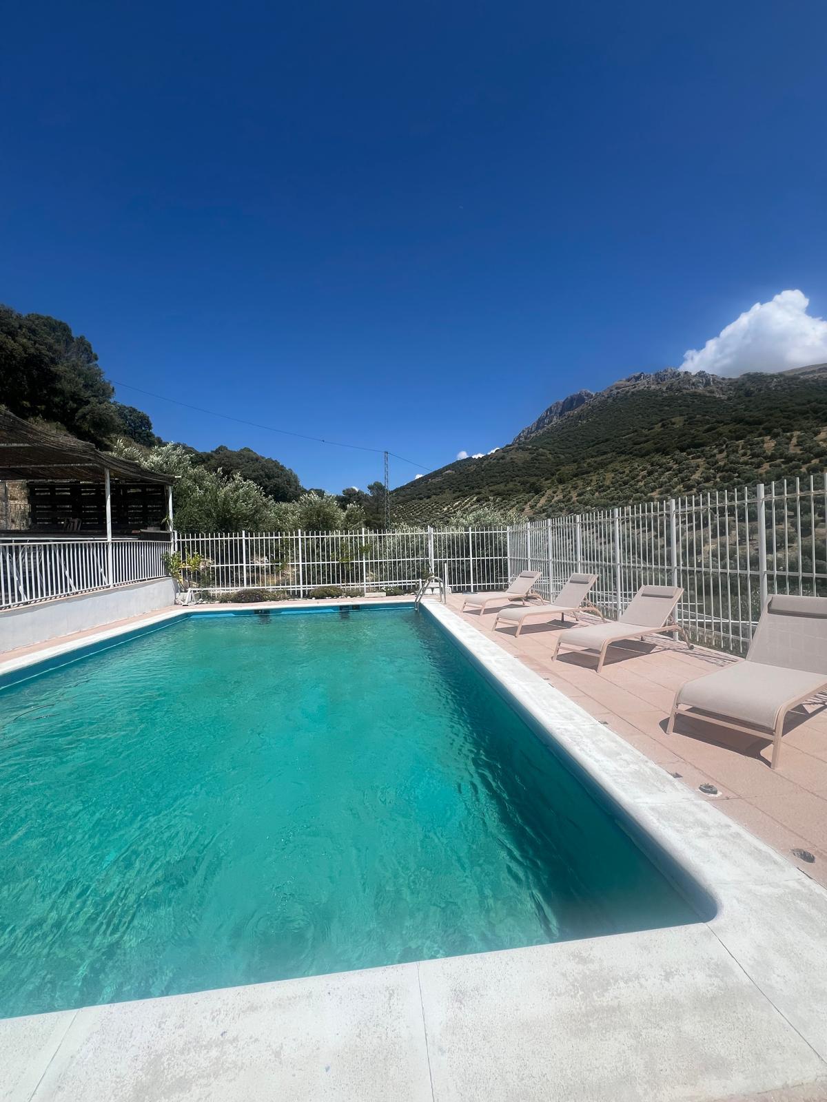 Piscina y zona de baño con vistas al monte
