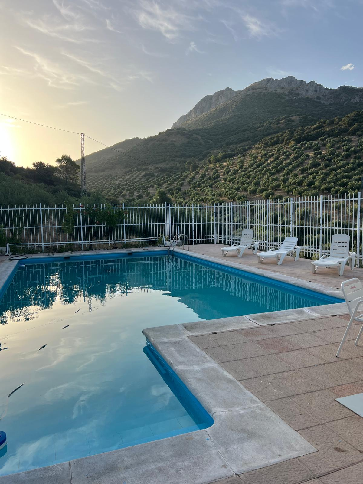 Piscina al anochecer con el cielo reflejado en el agua
