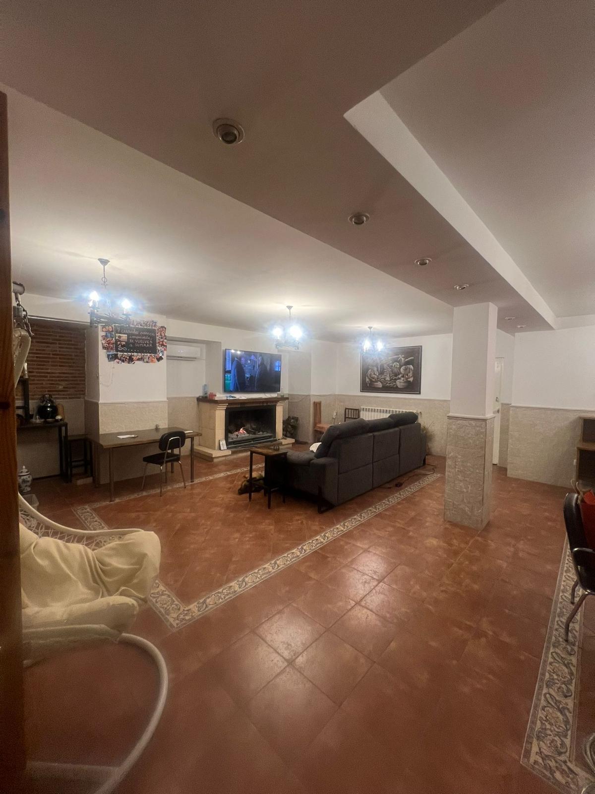 Salón amplio con sofás, chimenea y televisor