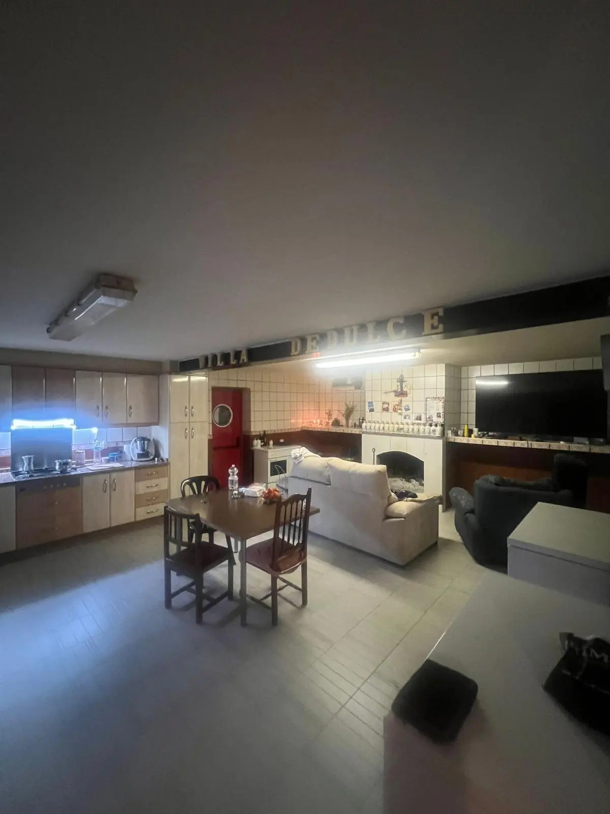 Salón con chimenea y cocina abierta de la casa rural