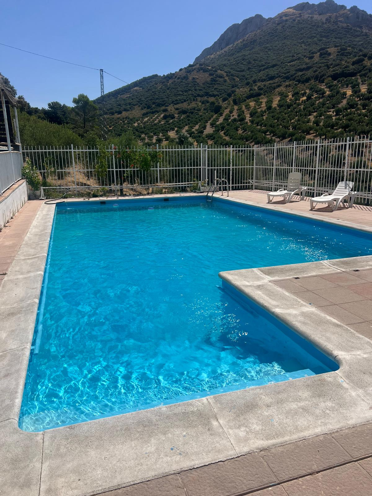 Piscina azul de Villa de Dulce en un día soleado con el monte al fondo