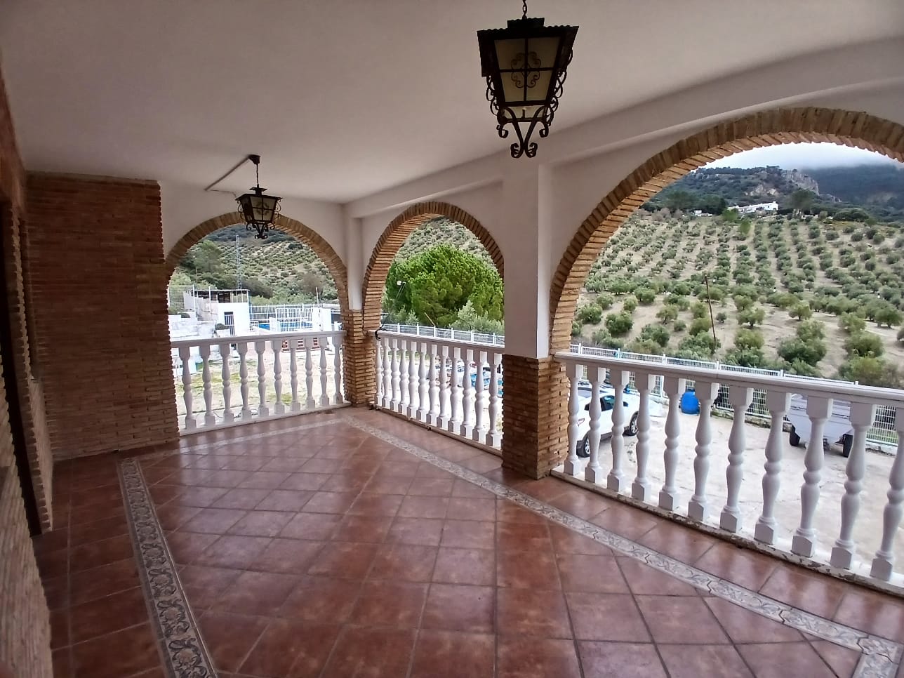 Terraza con arcos de ladrillo y balaustrada blanca